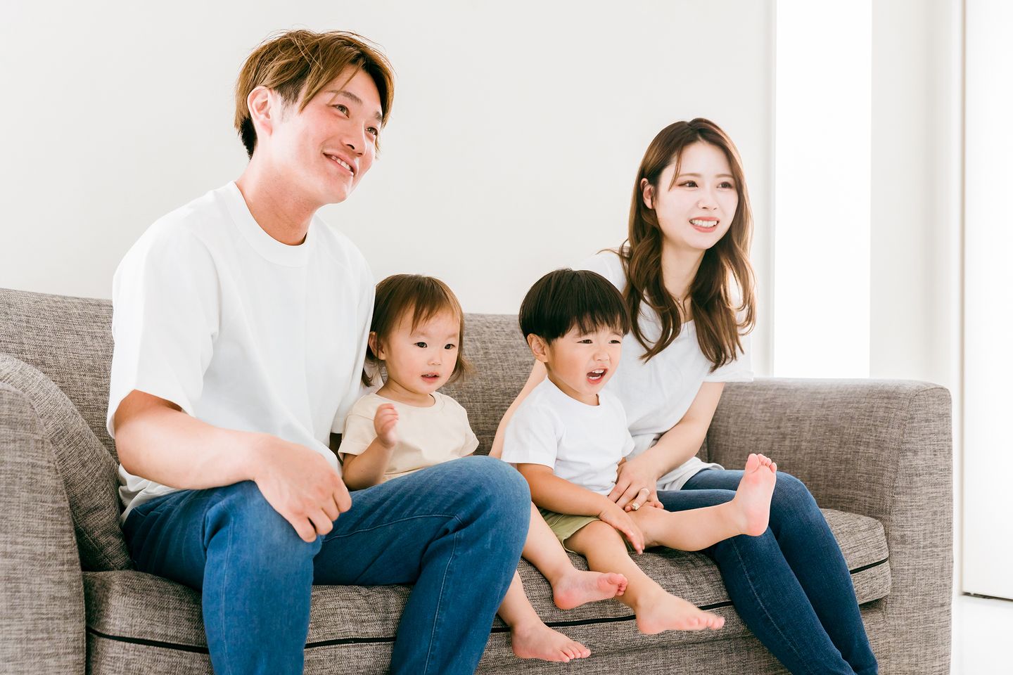 ソファで寄り添って笑う親子