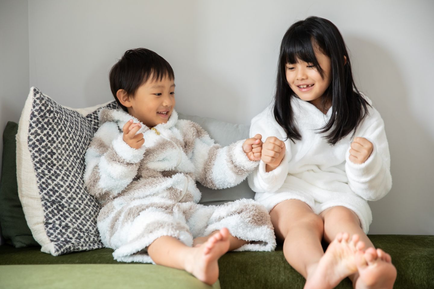 ソファで並んで遊ぶ姉と弟