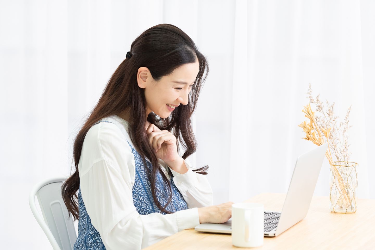 リビングでノートパソコンを見る母親