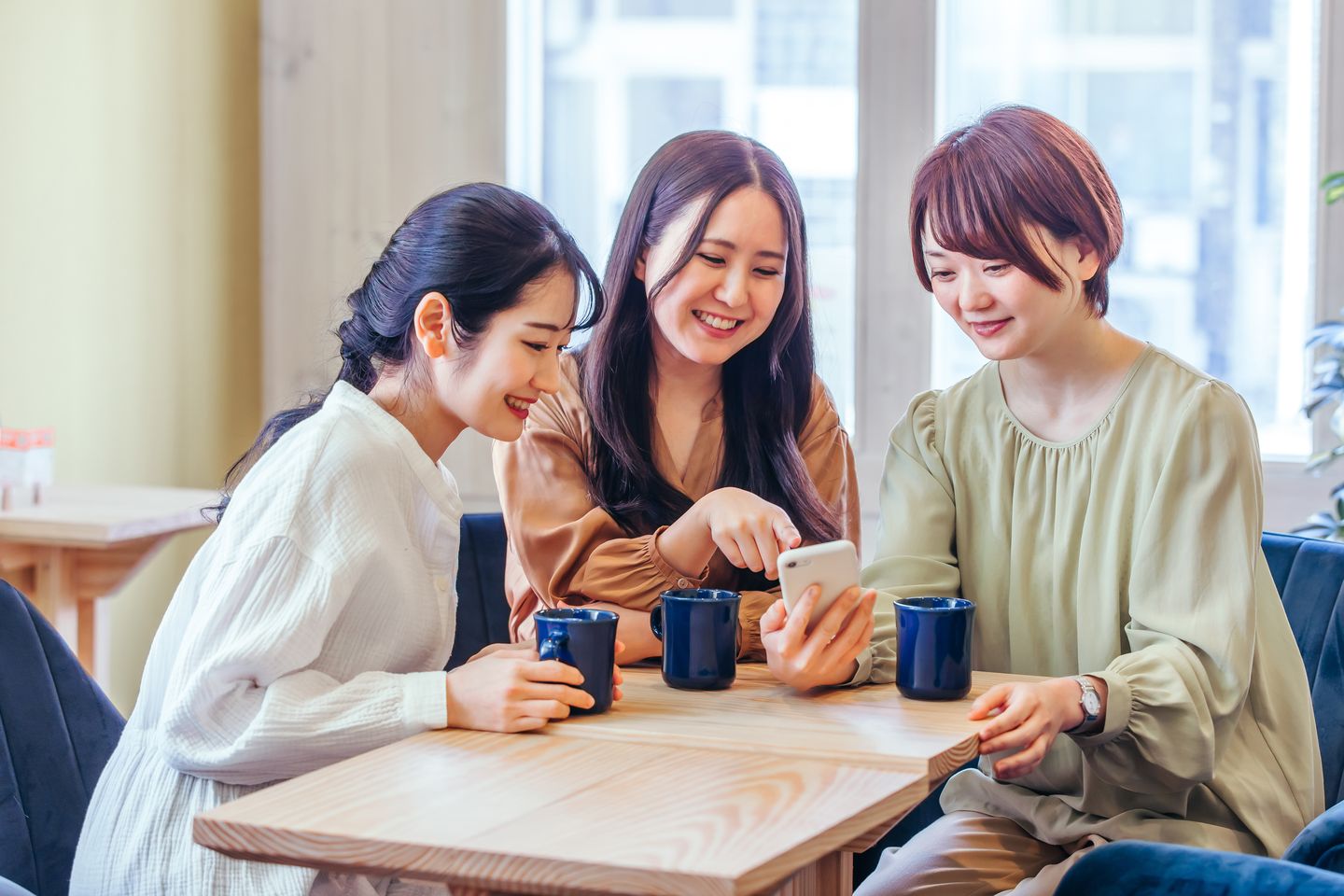 スマートフォンを一緒に見て笑う女性たち